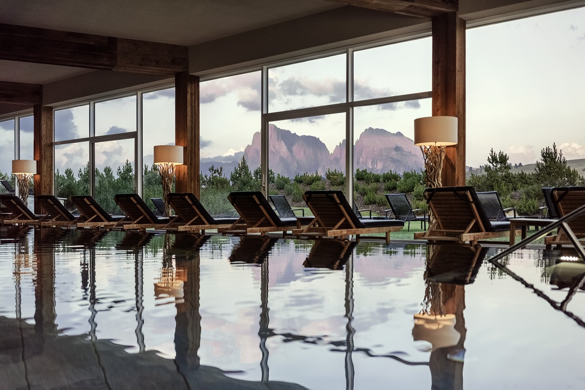 interior pool at COMO hotel with loungers facing a dolomite mountain view